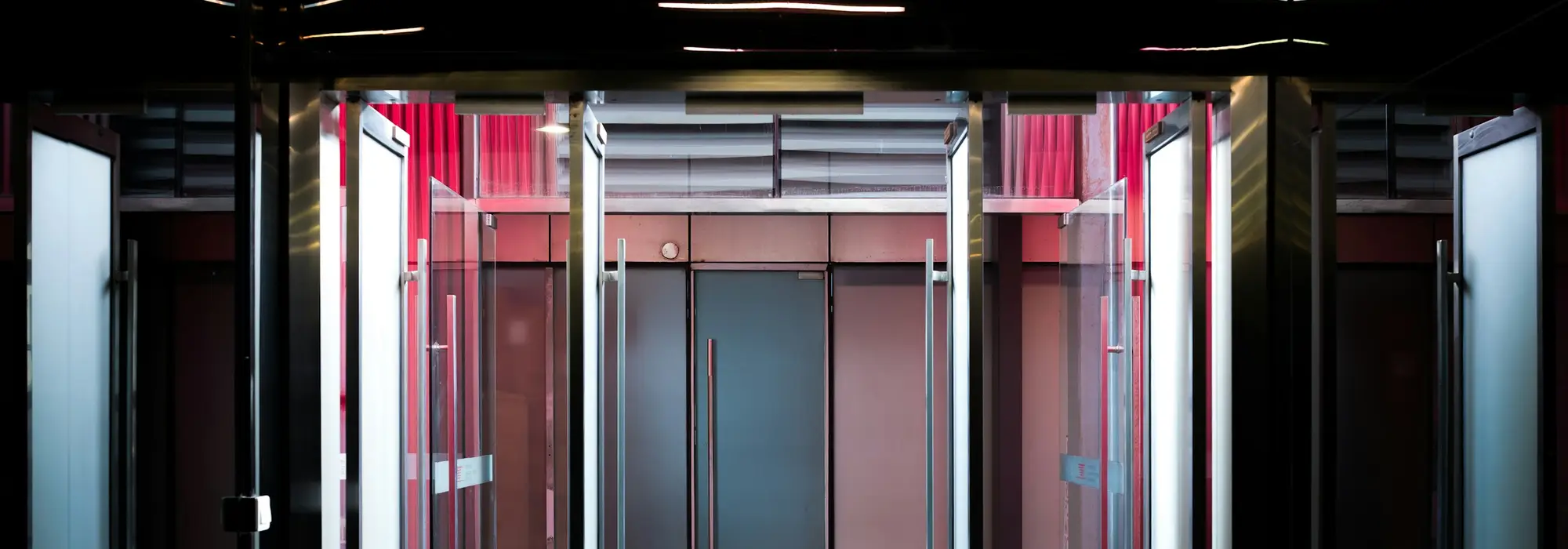 The glass revolving doors of a commercial building lobby at night
